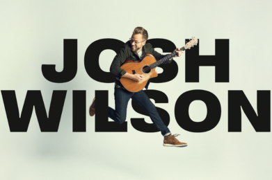 Josh Wilson holding guitar and jumping in mid air in front of text "Josh Wilson".