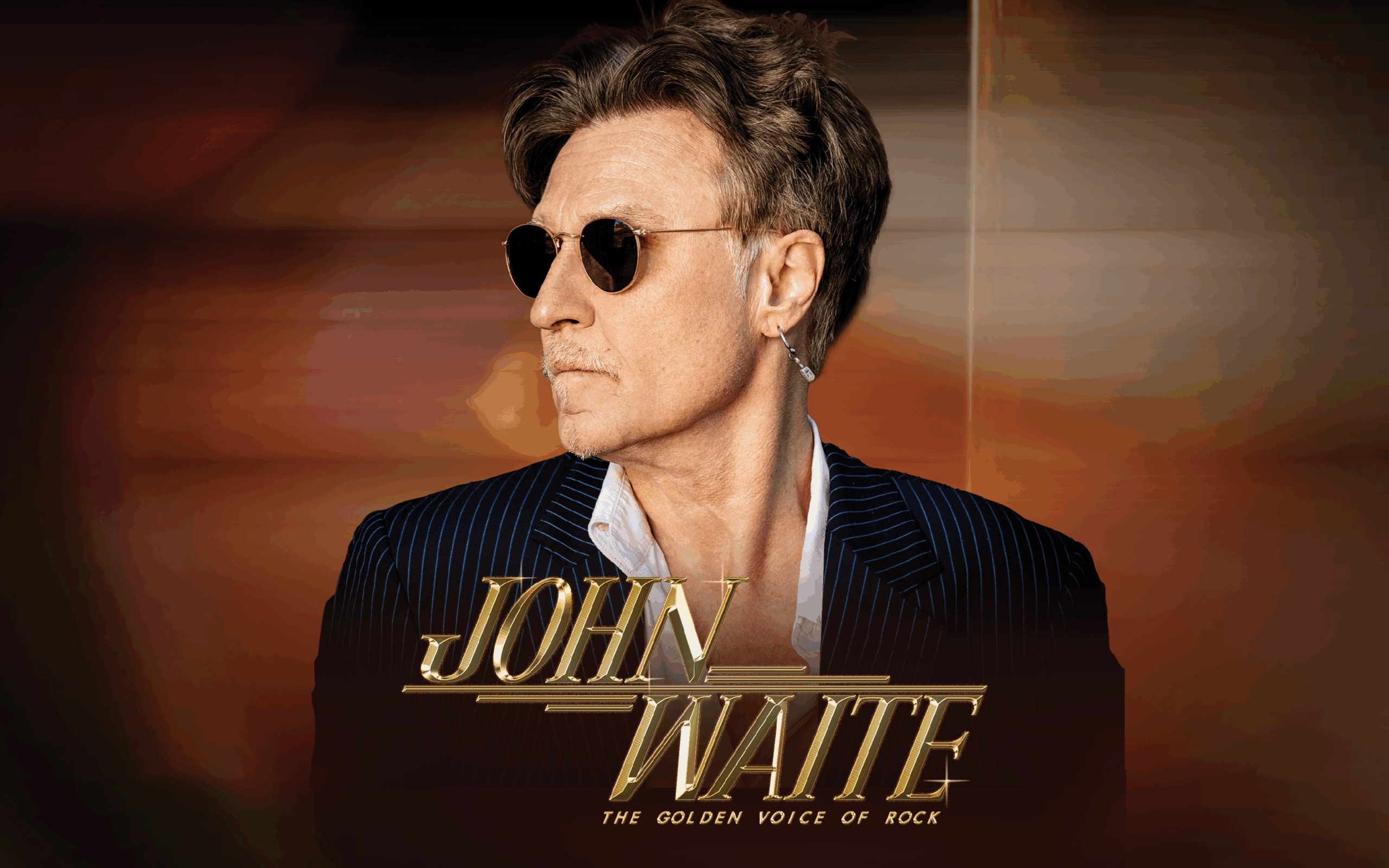 Promotional image of musician John Waite in a dark jacket against a black background. Bold text reads “John Waite.”