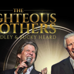 Promotional poster for The Righteous Brothers. Pictured are two performers singing into microphones. In gold, it reads "The Righteous Brothers."