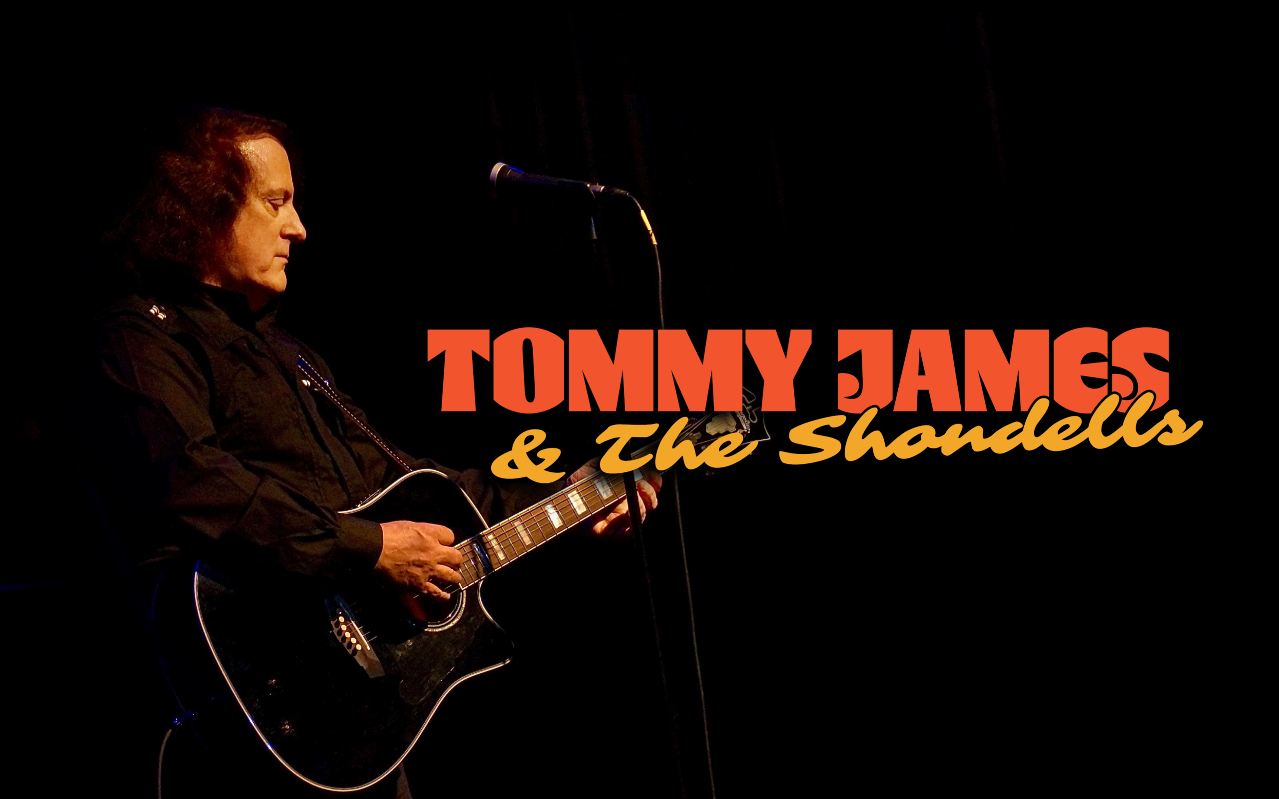 Promotional poster for Tommy James & The Shondells. Pictured is Tommy James playing guitar. Against a dark background, in yellow and orange it reads "Tommy James & The Shondells."